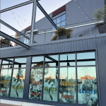 The external view of the Cleats building in Charleston, with large branded windows and a rooftop deck.