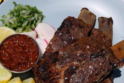 An image of CARNITAS RIBS prepared at new restaurant Colectivo in charleston, along with salsa, squash and radish