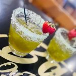 A yellow cocktail with a sugar rim and strawberry served at bar on the ave in North Charleston