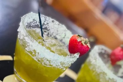 A yellow cocktail with a sugar rim and strawberry served at bar on the ave in North Charleston