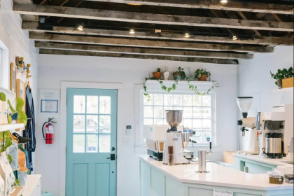 The interior of the original sightsee coffee and retail shop in downtown charleston, with a coffee service counter and items for sale on the walls