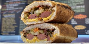 Two halves of Snarf's Sandwiches' hot dog sandwich stacked on top of each other