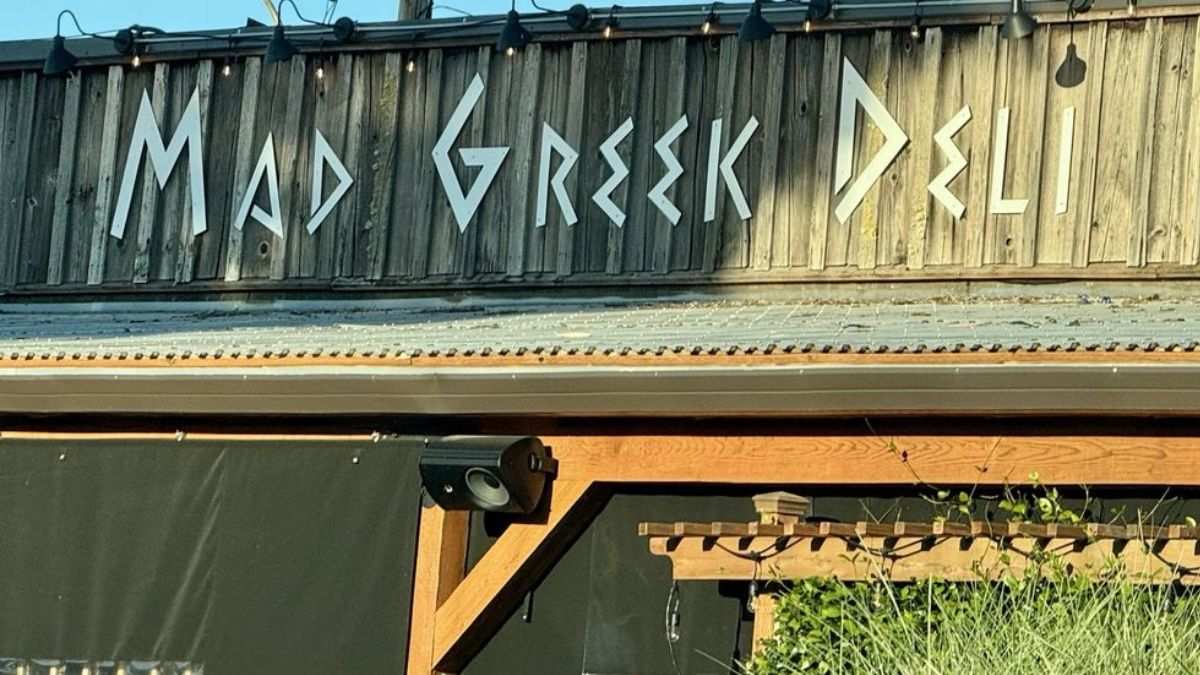 This image shows a storefront view of Mad Greek Deli